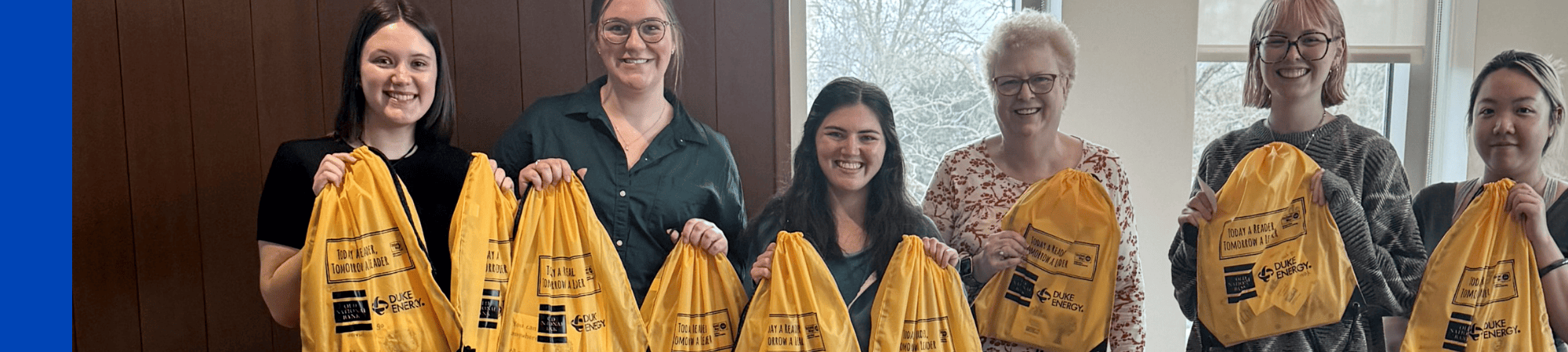 Group of volunteers holding book bags